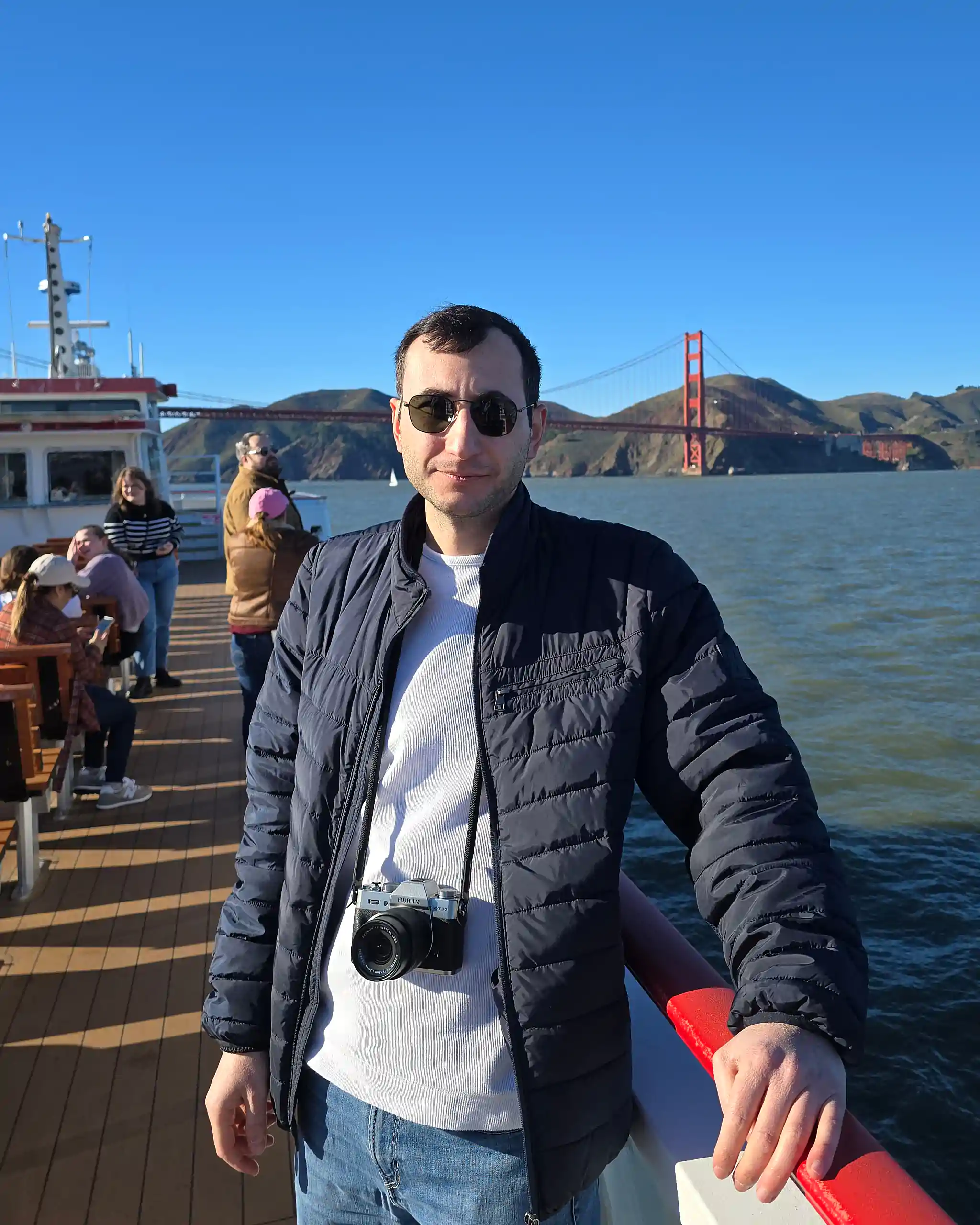 Levan Kelesidis on a boat in San Francisco with the golden gate bridge behind